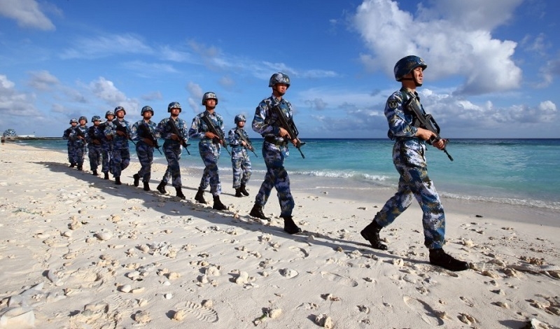守衛在南沙群島永暑礁上的海軍官兵在沙灘上巡邏，新華社記者 查春明 攝